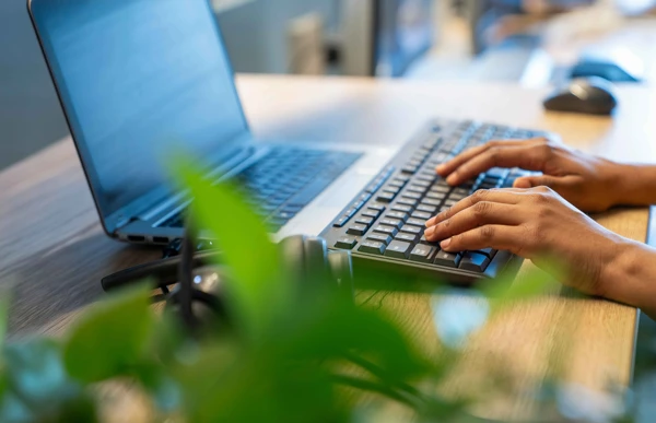 Person typing on laptop keyboard