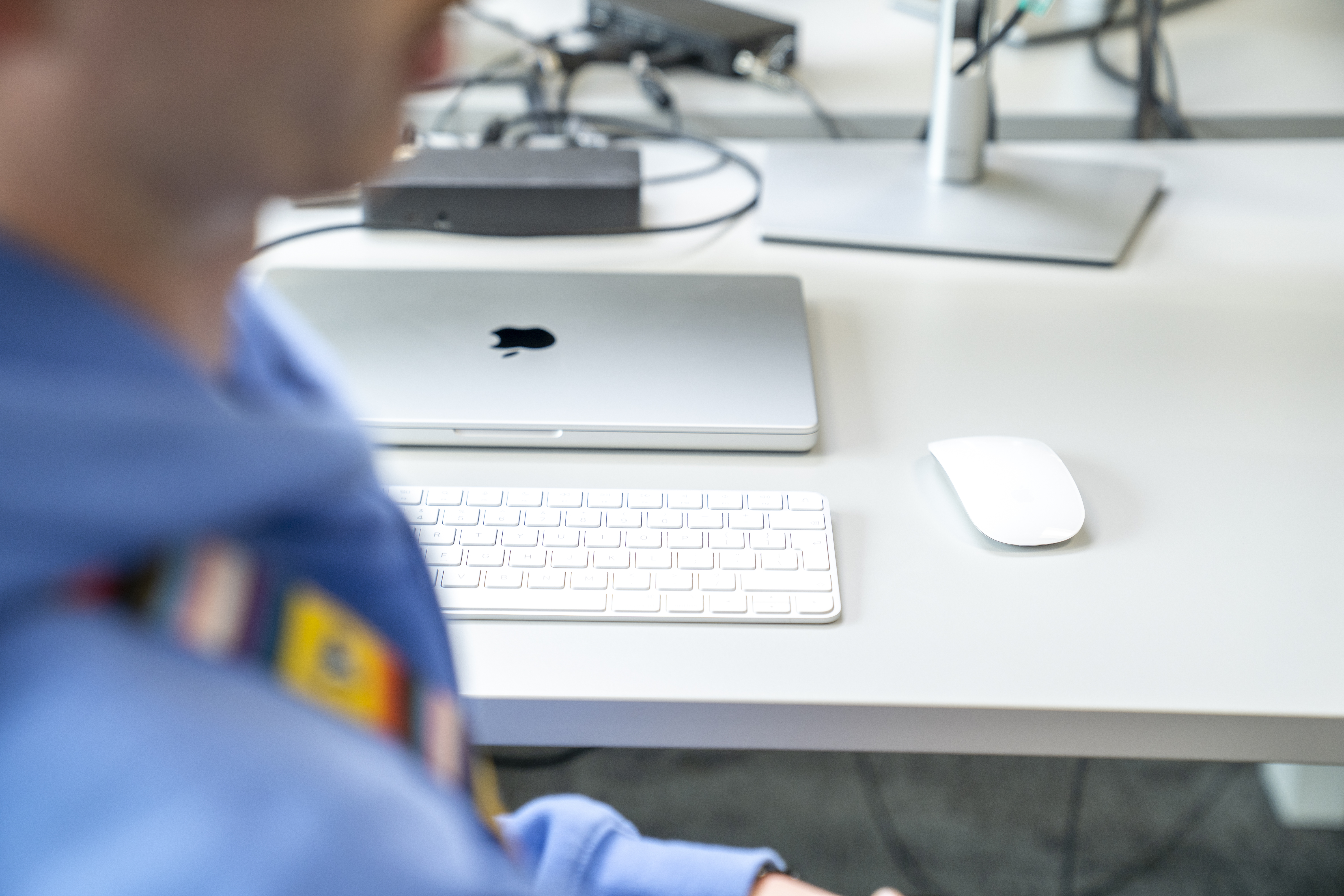 Person sitting at their desk with their laptop on their desk