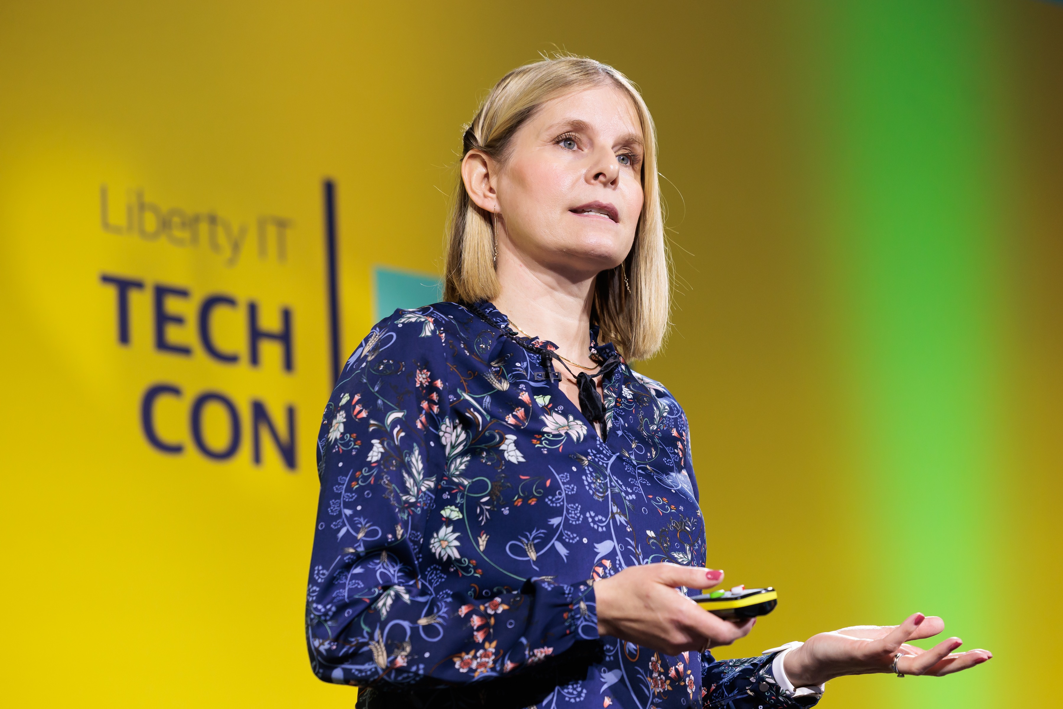 Susan presenting on stage with Liberty IT TechCon branding in background