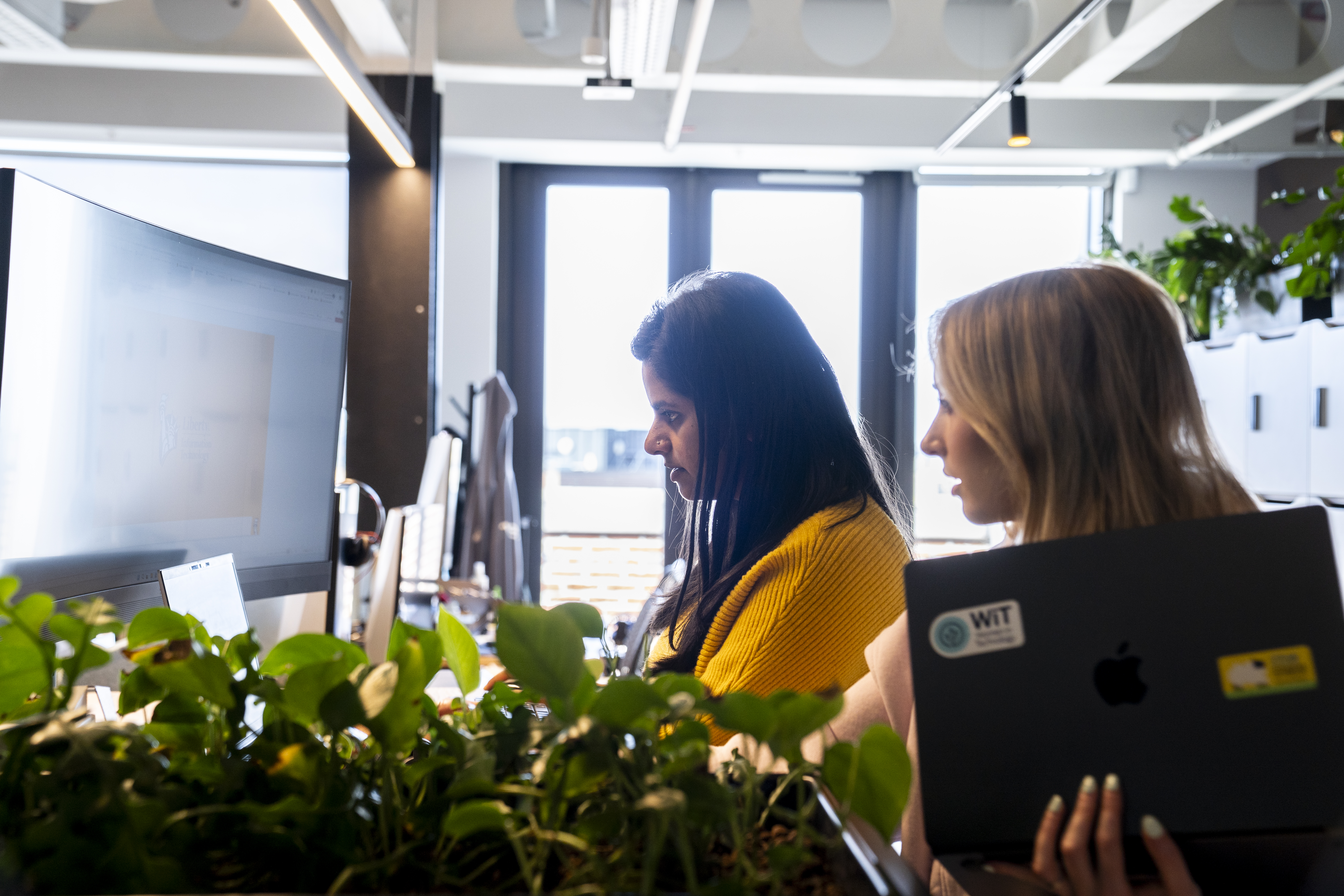 Employees talking in a Liberty IT office.