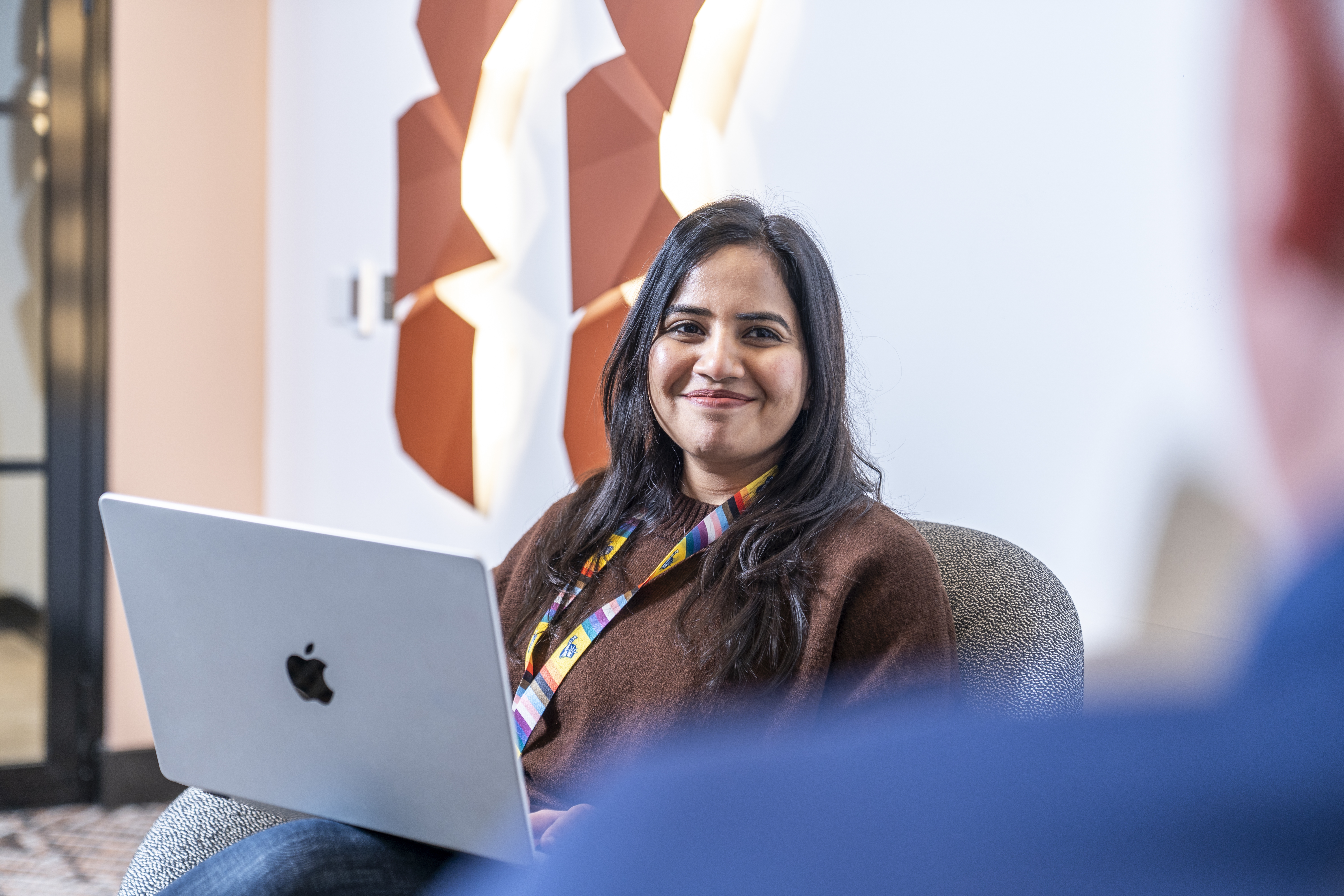 Employee holding a laptop and smiling during a meeting
