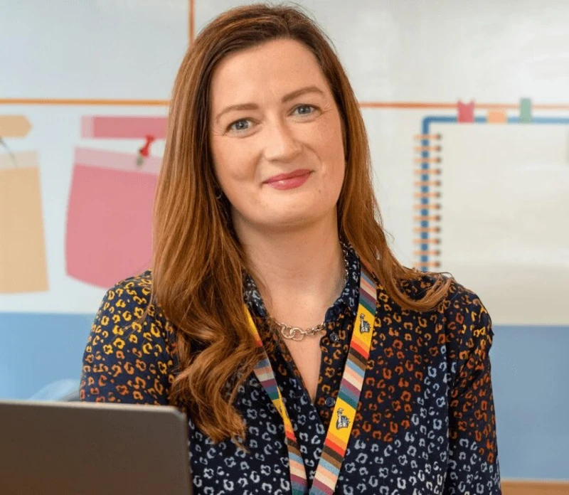 Berni, an Engineering Manager at Liberty IT, smiling at her desk