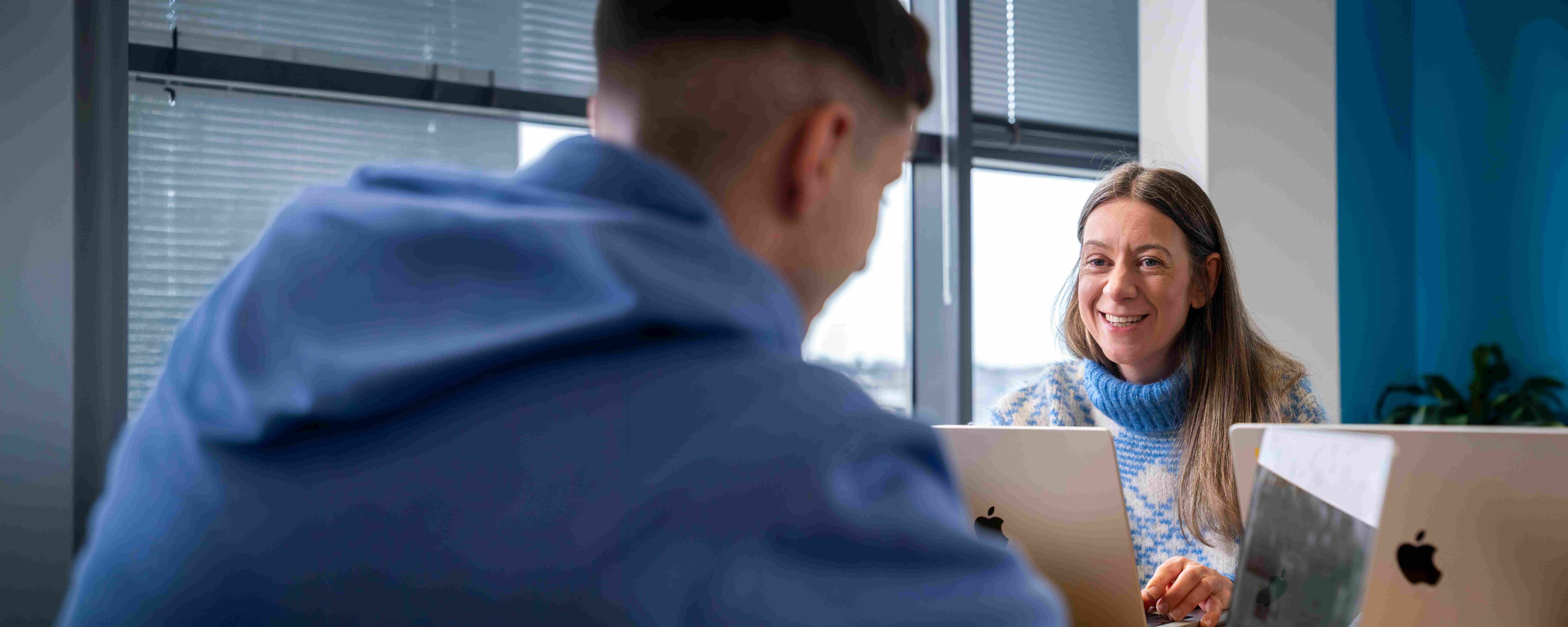 Employees collaborating during a meeting in a Liberty IT office.