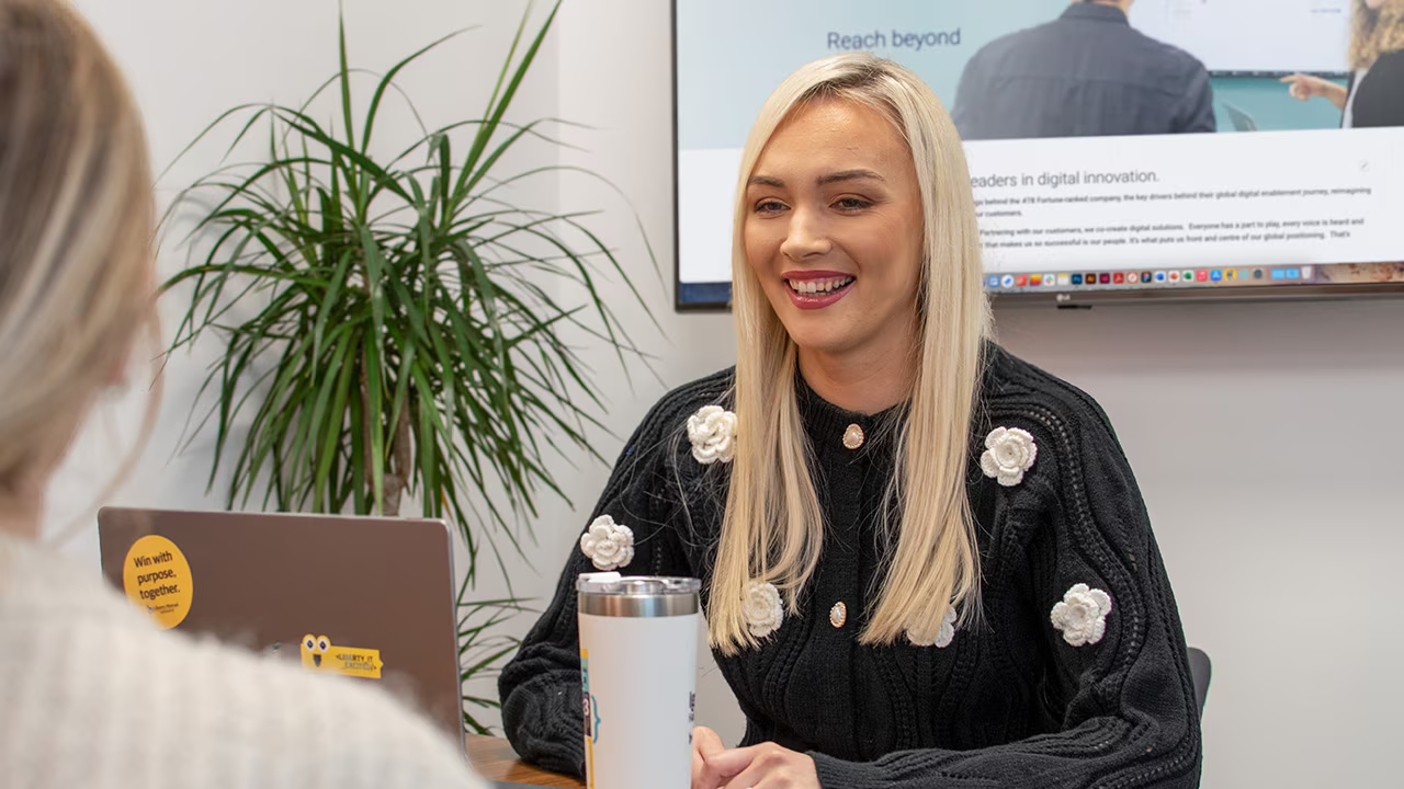 Natasha, Solutions Engineer, smiling during a meeting in an office setting