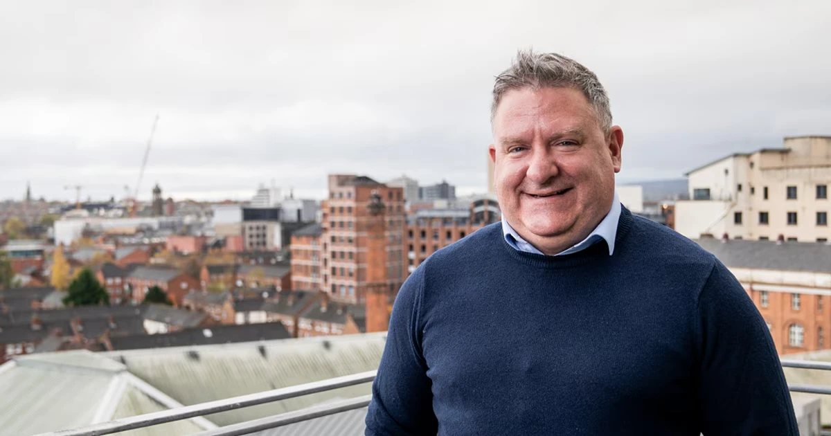 Simon smiling on a balcony