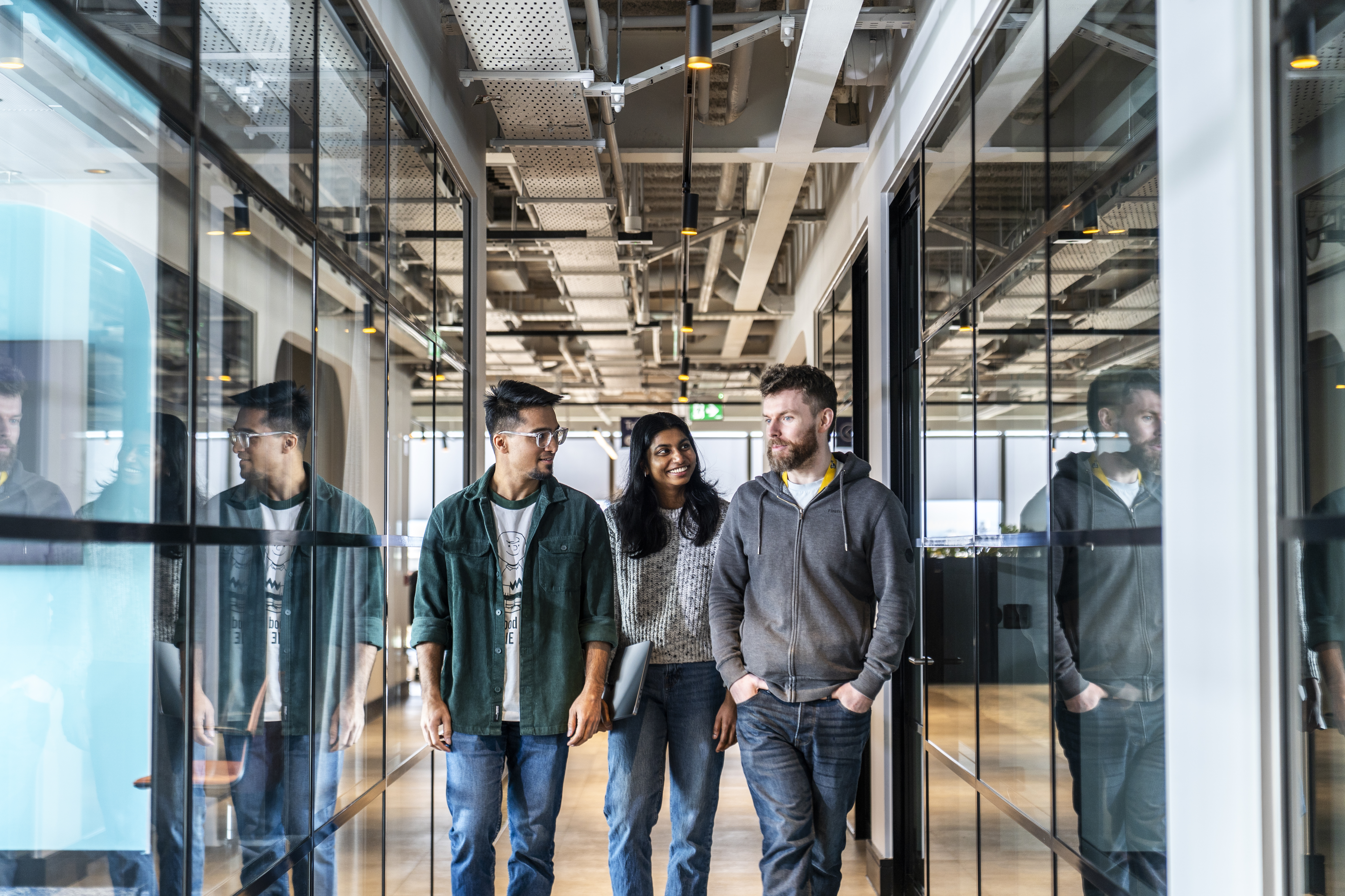 Employees walking through a modern workspace in the Liberty IT Dublin office.