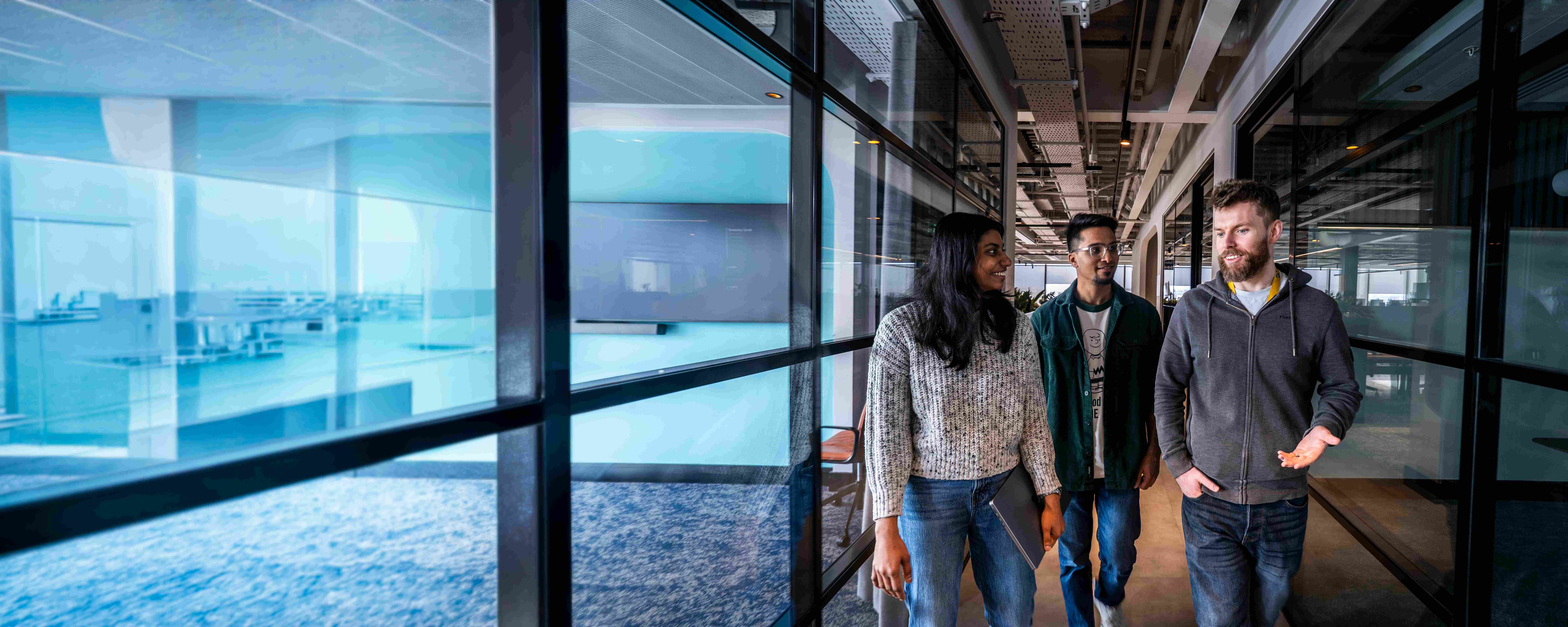 Three employees walking together through an office