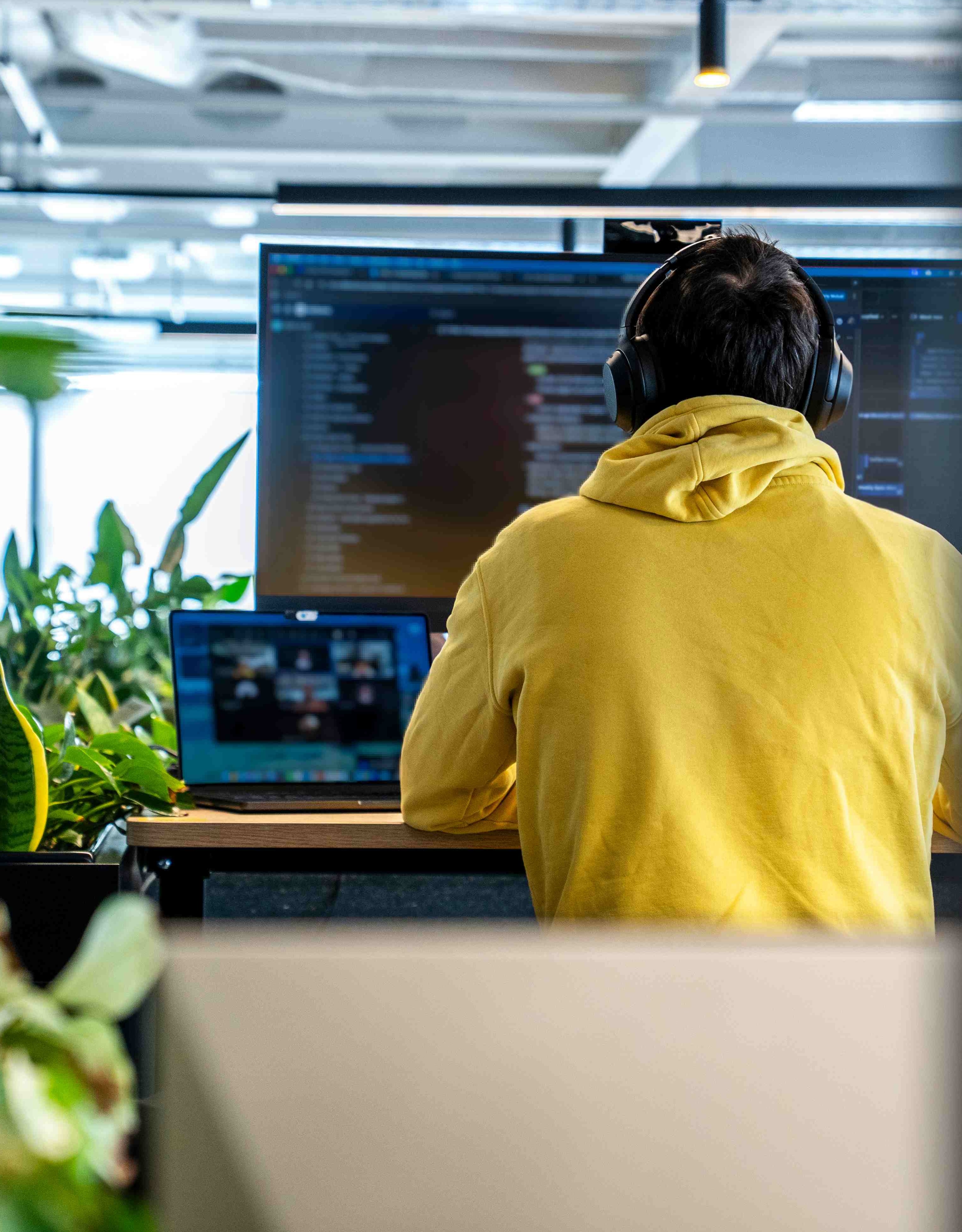 Employee in yellow hoodie working at desk