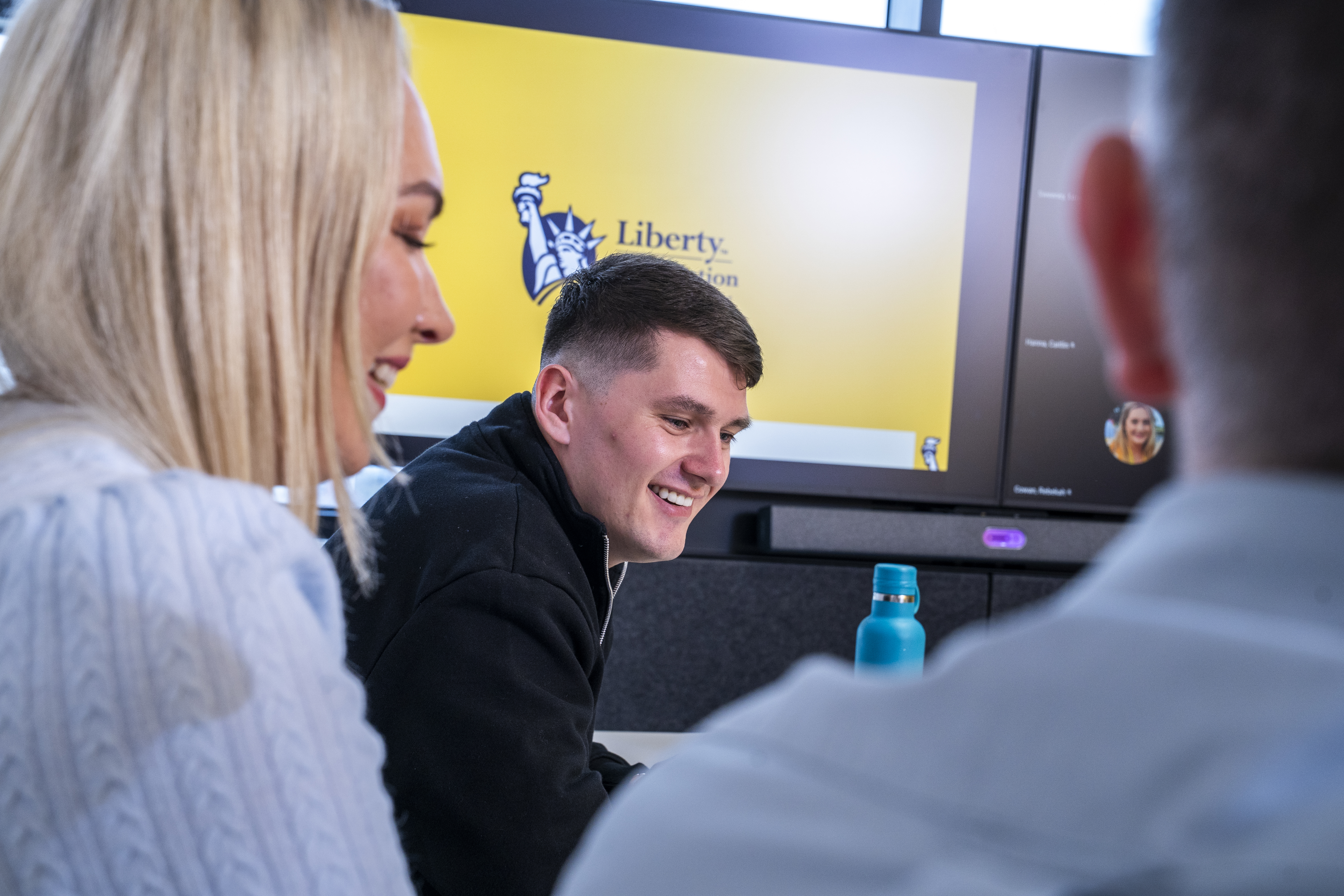 Employees collaborating during a meeting at Liberty IT.