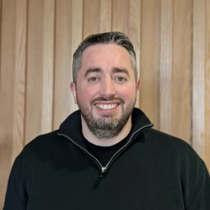 Aidan, Engineering Manager, smiling in office