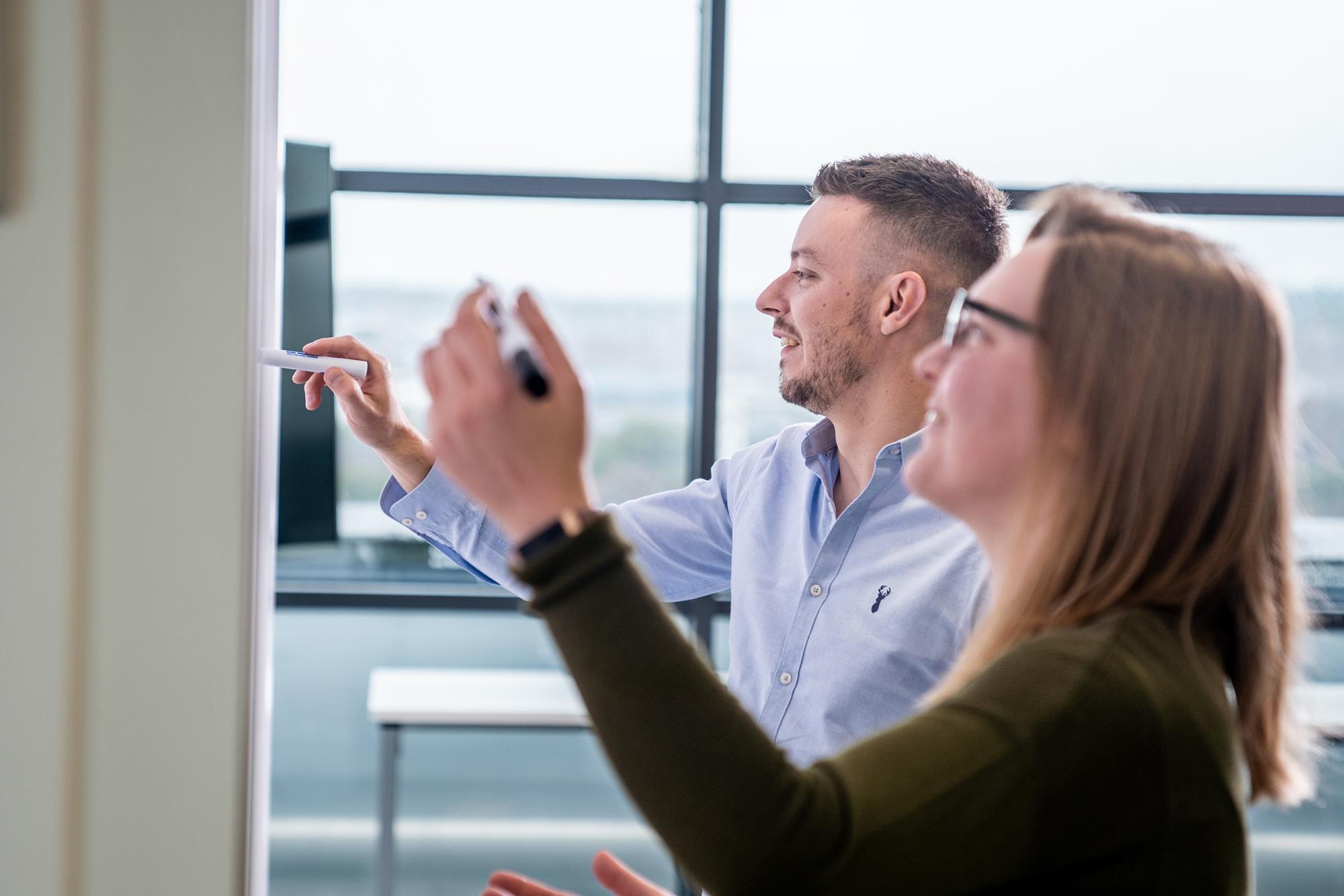 Photo of man and woman writing on wall