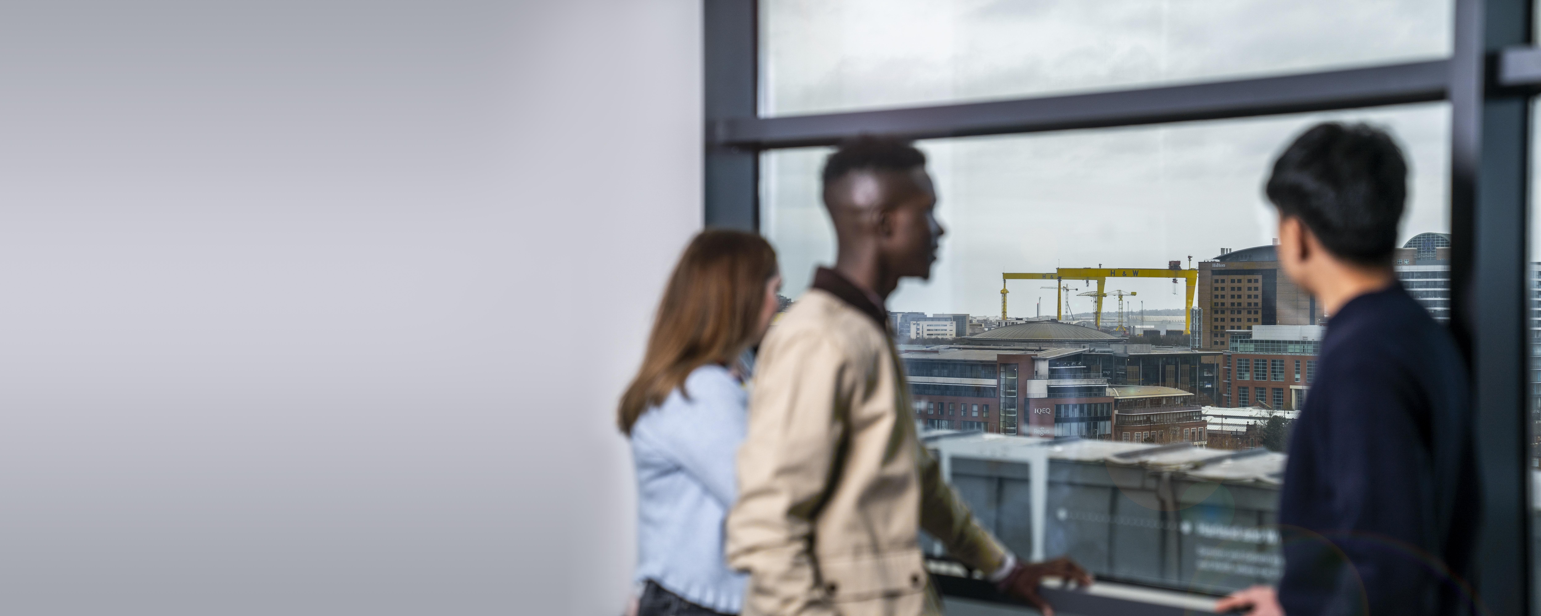 Picture of three employees overlooking Belfast